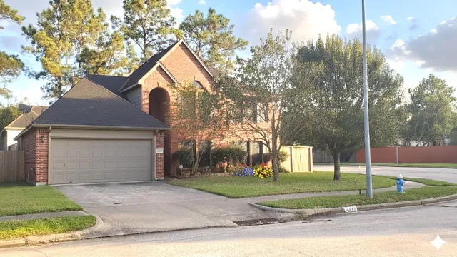 a view of a house with a yard and large tree