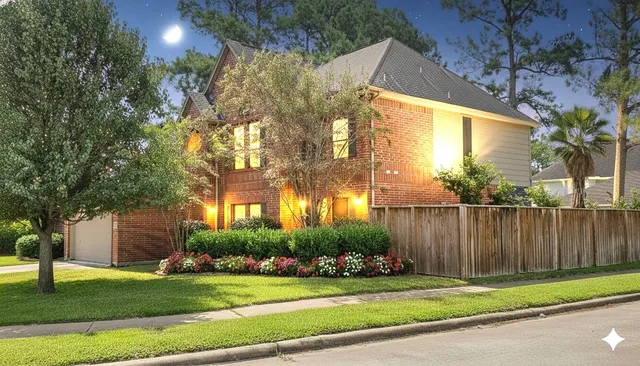 a view of a fountain in front of a brick house with large windows