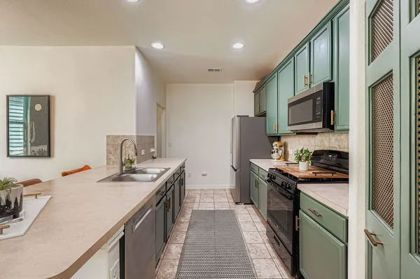 a kitchen with a sink stove top oven and refrigerator