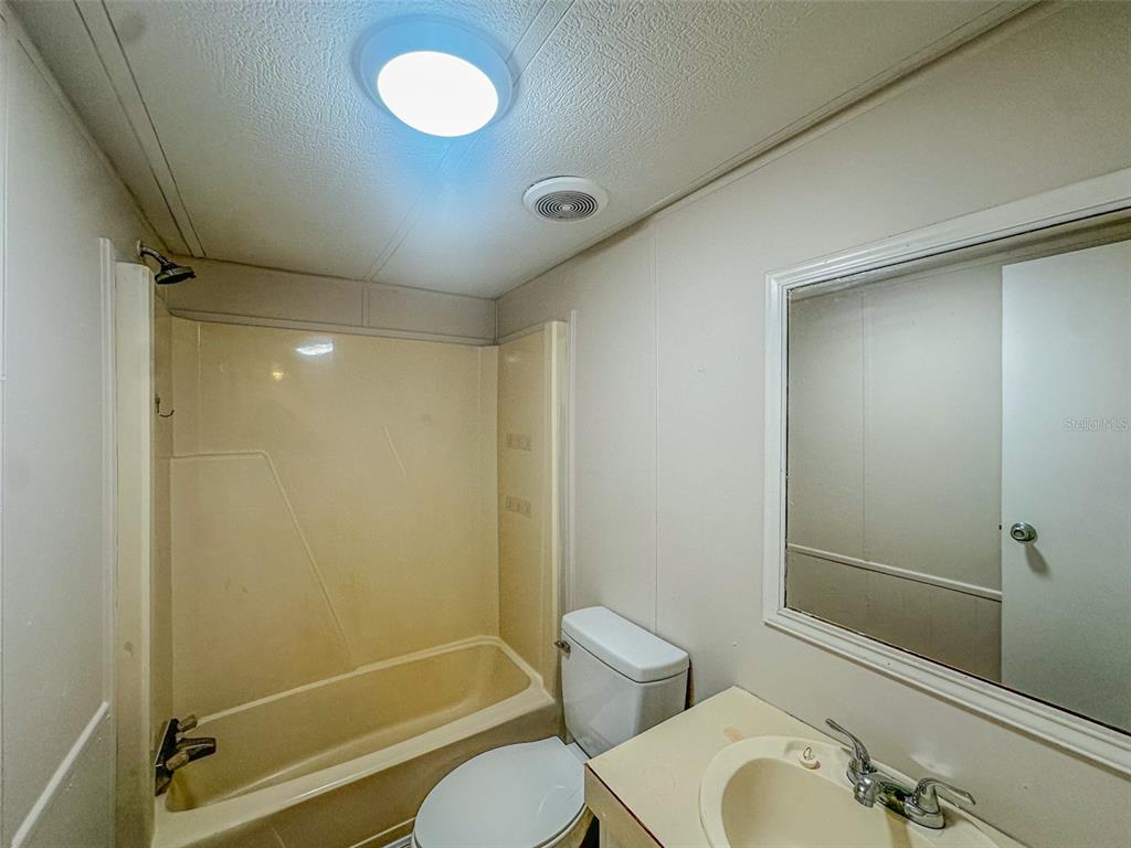 2218 Ellie Road, Unit 1 Auburndale, FL 33823 - Photo 13 of 21 a bathroom with a sink mirror vanity and toilet