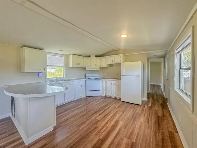 a kitchen with cabinets and wooden floor