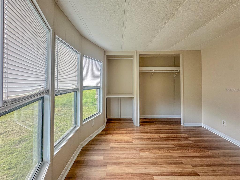 2218 Ellie Road, Unit 1 Auburndale, FL 33823 - Photo 6 of 21 an empty room with wooden floor and windows