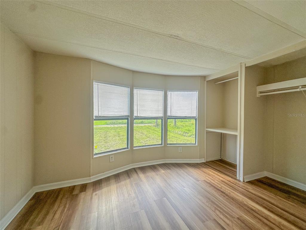 2218 Ellie Road, Unit 1 Auburndale, FL 33823 - Photo 7 of 21 an empty room with wooden floor and windows