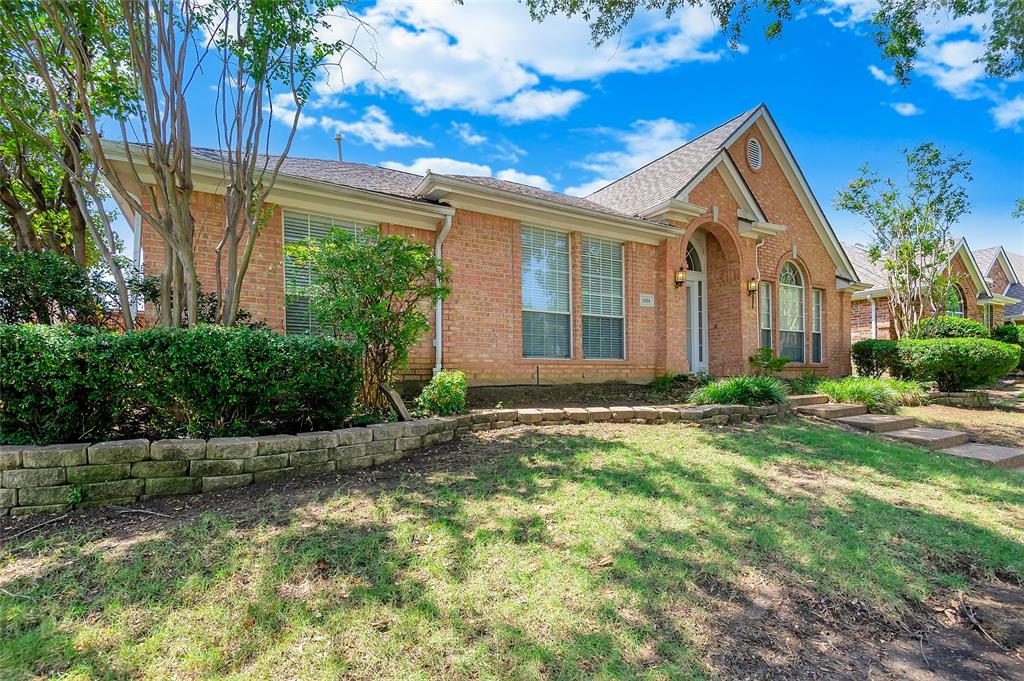 1404 Ranch Hill Drive Irving, TX 75063 - Photo 2 of 31 Brick exterior featuring an arched entryway, multiple windows, and a gabled roofline