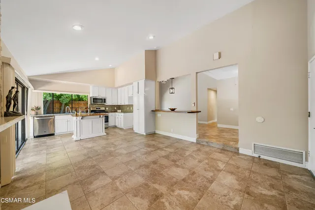 a view of empty room with a kitchen