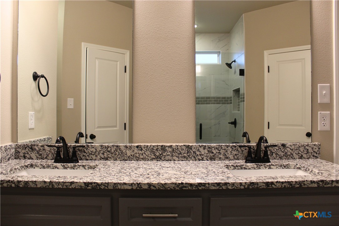 3824 Keller Road Temple, TX 76504 - Photo 15 of 22 a bathroom with a granite countertop sink and a mirror