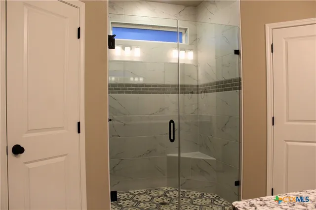 a bathroom with a glass shower door