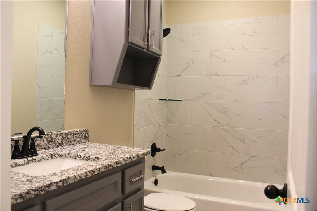 3824 Keller Road Temple, TX 76504 - Photo 21 of 22 a bathroom with a granite countertop sink toilet and bathtub