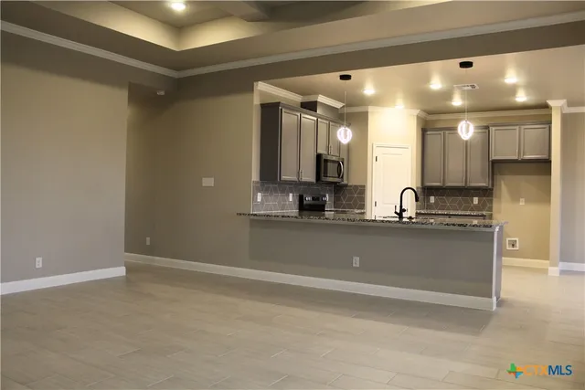 a view of kitchen with stainless steel appliances wooden floor