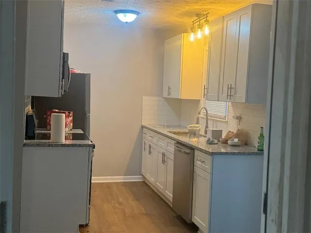 a view of backyard with large trees and wooden fence