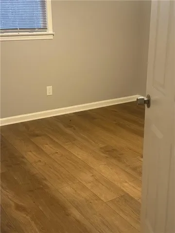 a view of a small space with wooden floor and a window