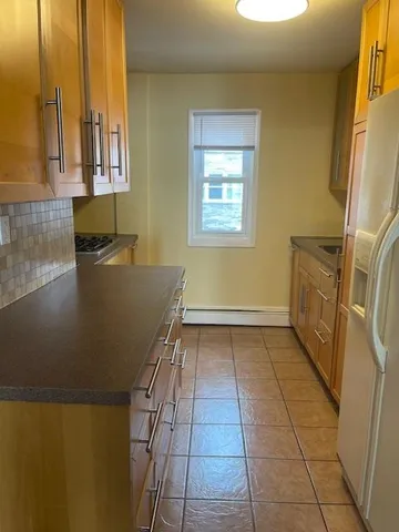 a view of a kitchen with fridge and window
