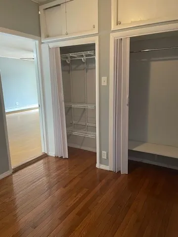 an empty room with wooden floor and closet