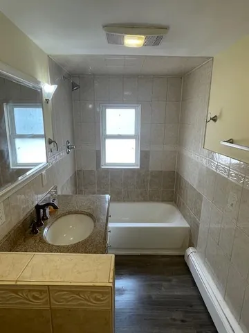 a bathroom with a sink a bathtub and a window