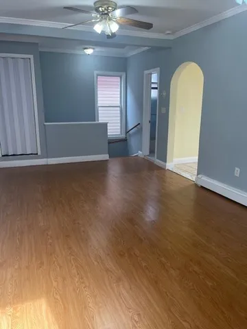 a view of a livingroom with wooden floor and a chandelier