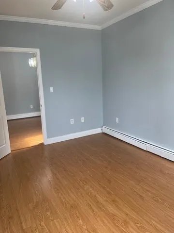 a view of empty room with wooden floor