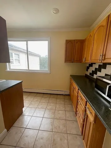 a view of a kitchen with a sink a microwave and cabinets
