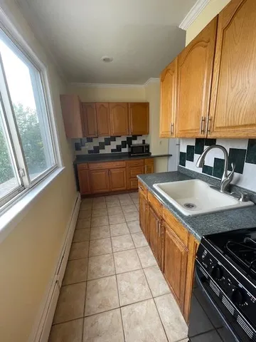 a kitchen with a sink a stove cabinets and a window