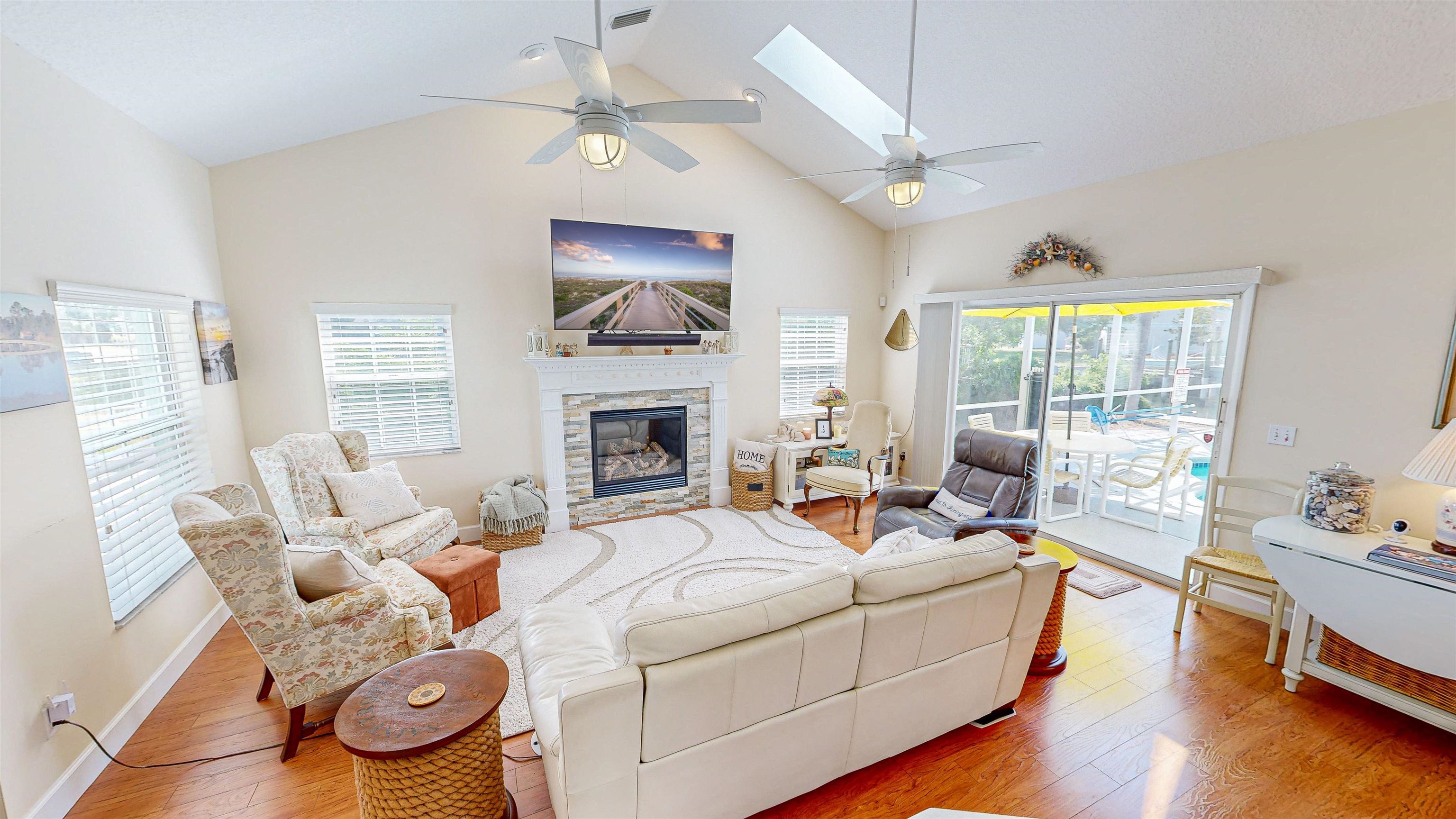 253 Treasure Beach Road St. Augustine, FL 32080 - Photo 12 of 52 a living room with furniture a fireplace and a flat screen tv