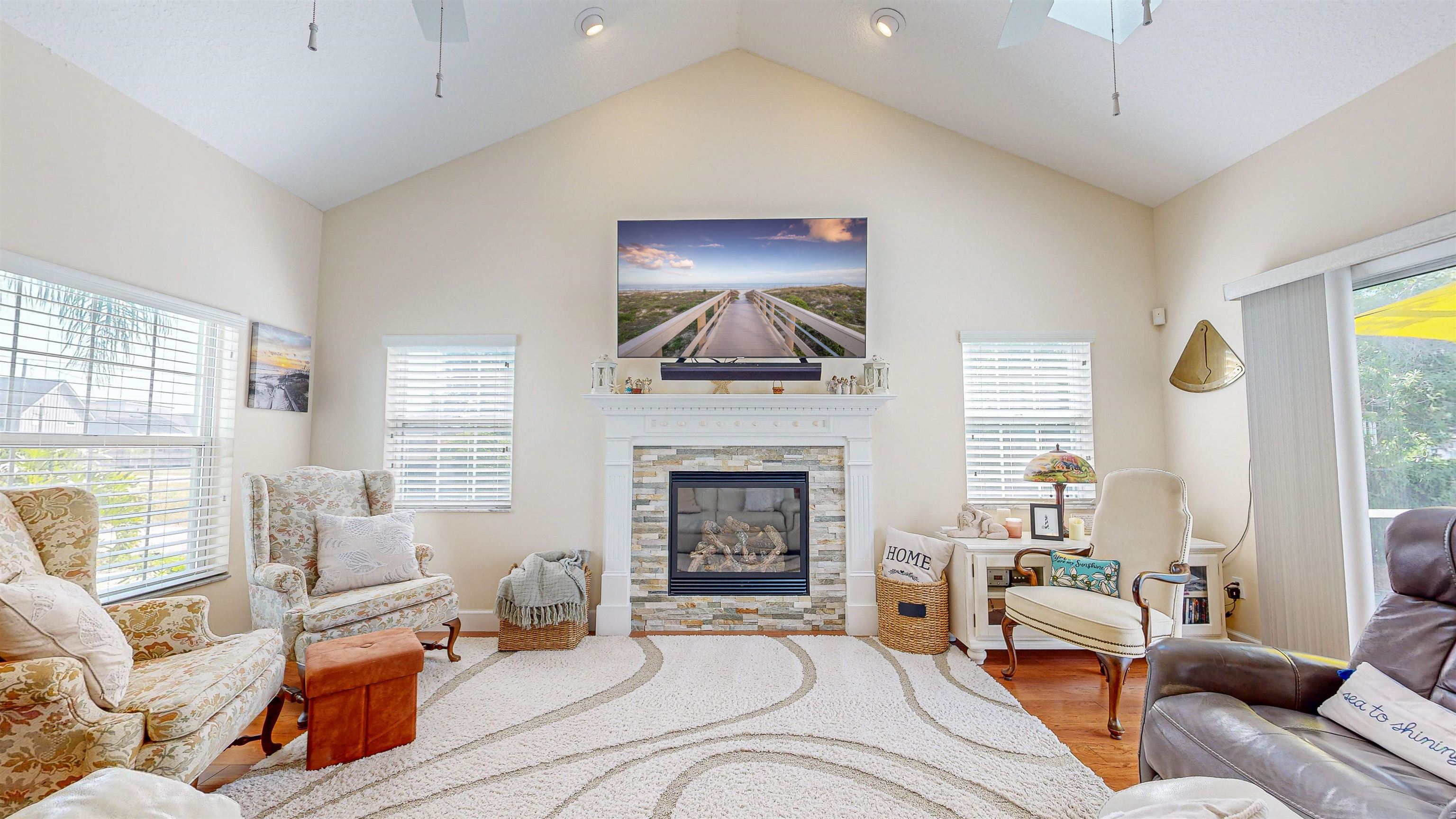 253 Treasure Beach Road St. Augustine, FL 32080 - Photo 13 of 52 a living room with furniture a fireplace and a flat screen tv
