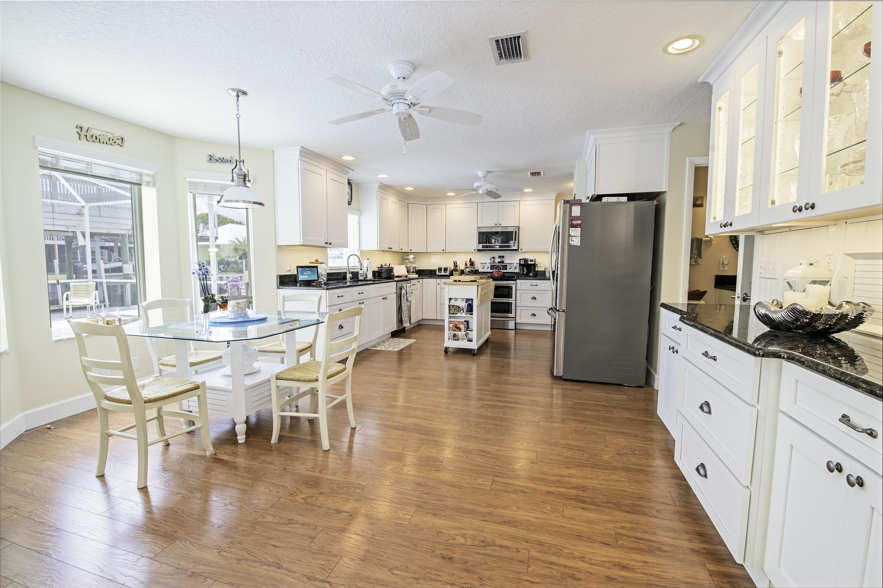 253 Treasure Beach Road St. Augustine, FL 32080 - Photo 16 of 52 a kitchen with stainless steel appliances a dining table chairs refrigerator and cabinets