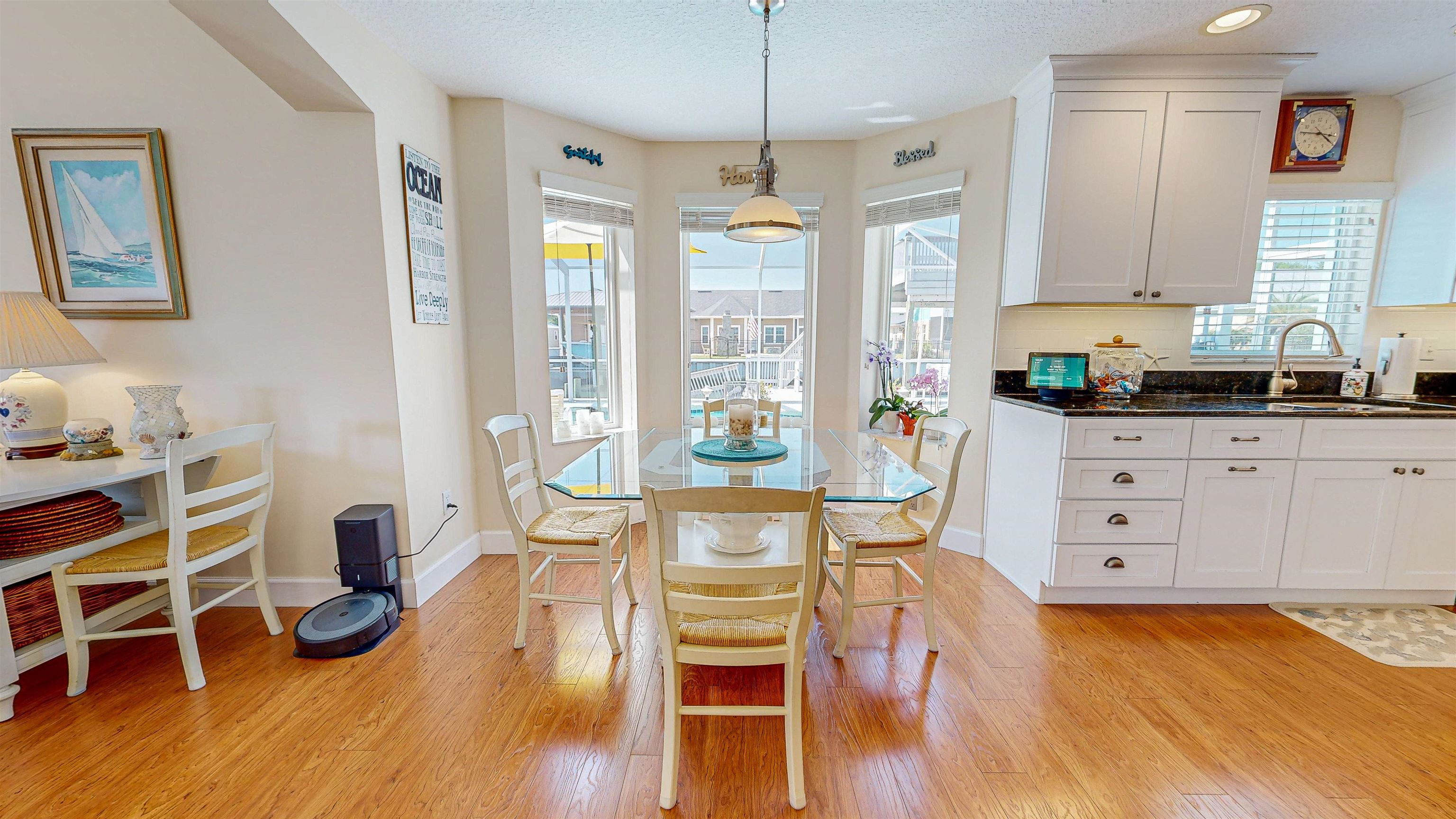 253 Treasure Beach Road St. Augustine, FL 32080 - Photo 18 of 52 a view of a dining room with furniture a chandelier and wooden floor