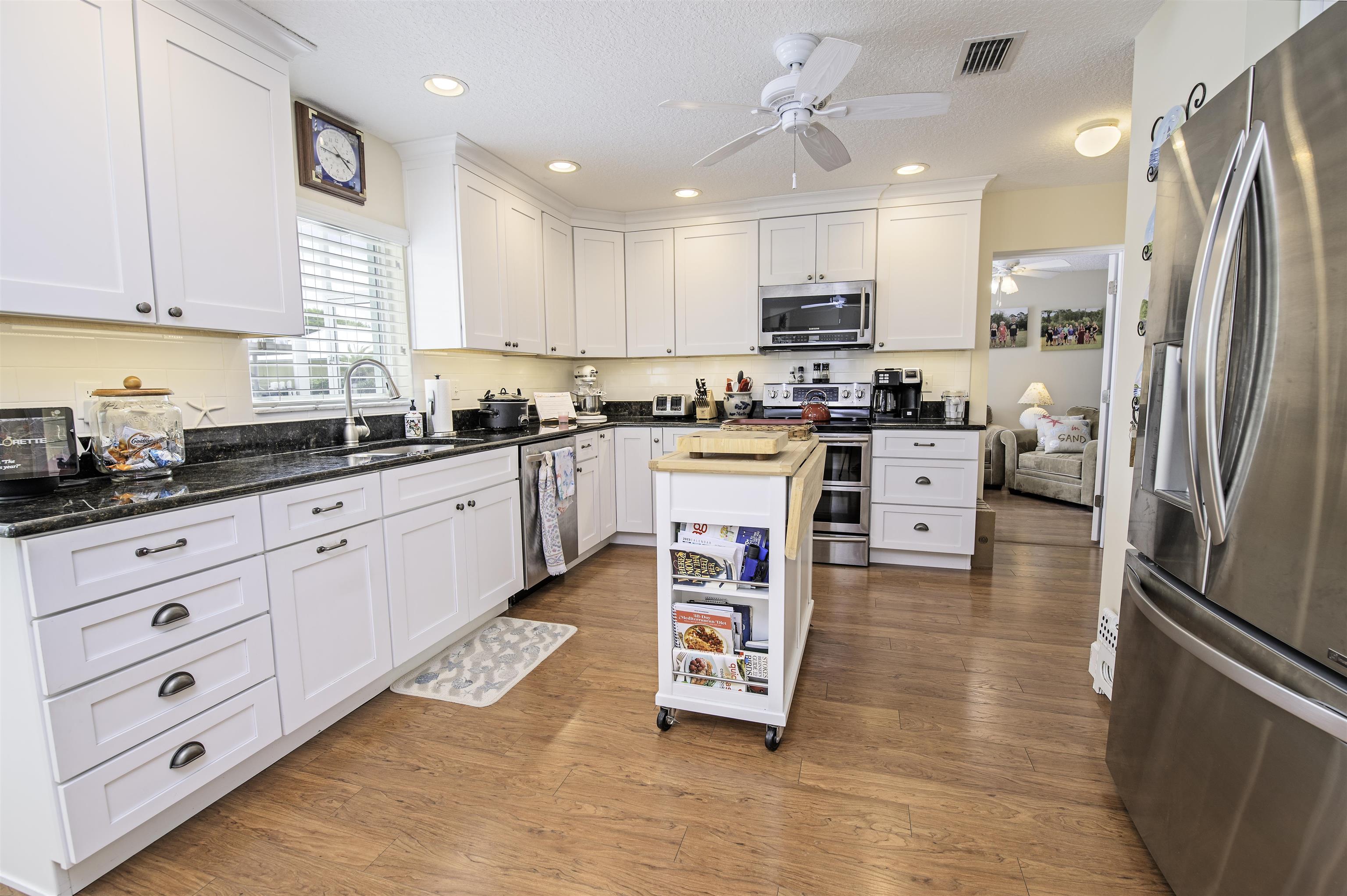 253 Treasure Beach Road St. Augustine, FL 32080 - Photo 19 of 52 a kitchen with stainless steel appliances granite countertop a refrigerator sink and cabinets