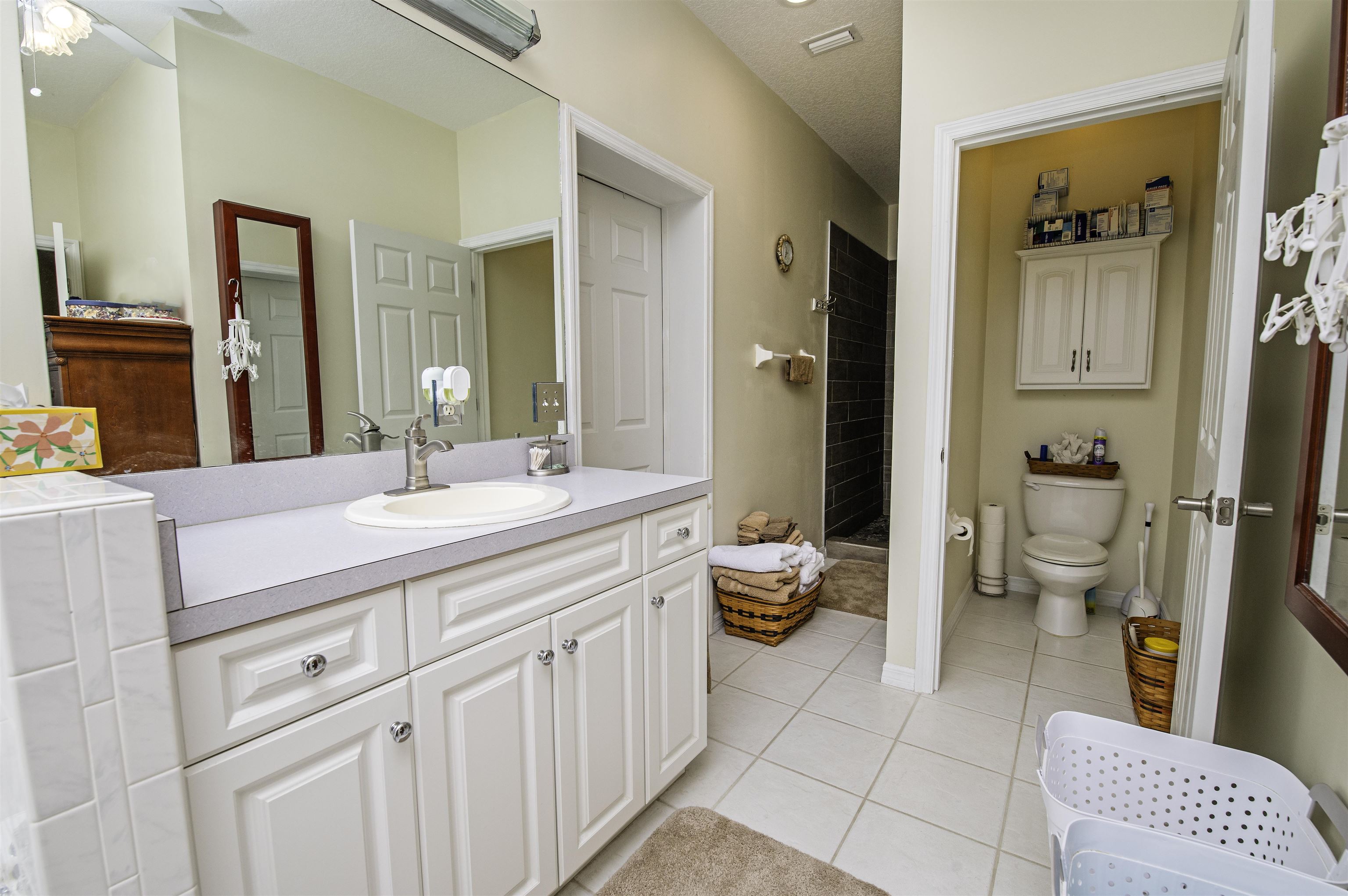 253 Treasure Beach Road St. Augustine, FL 32080 - Photo 29 of 52 a spacious bathroom with a double vanity sink toilet and shower