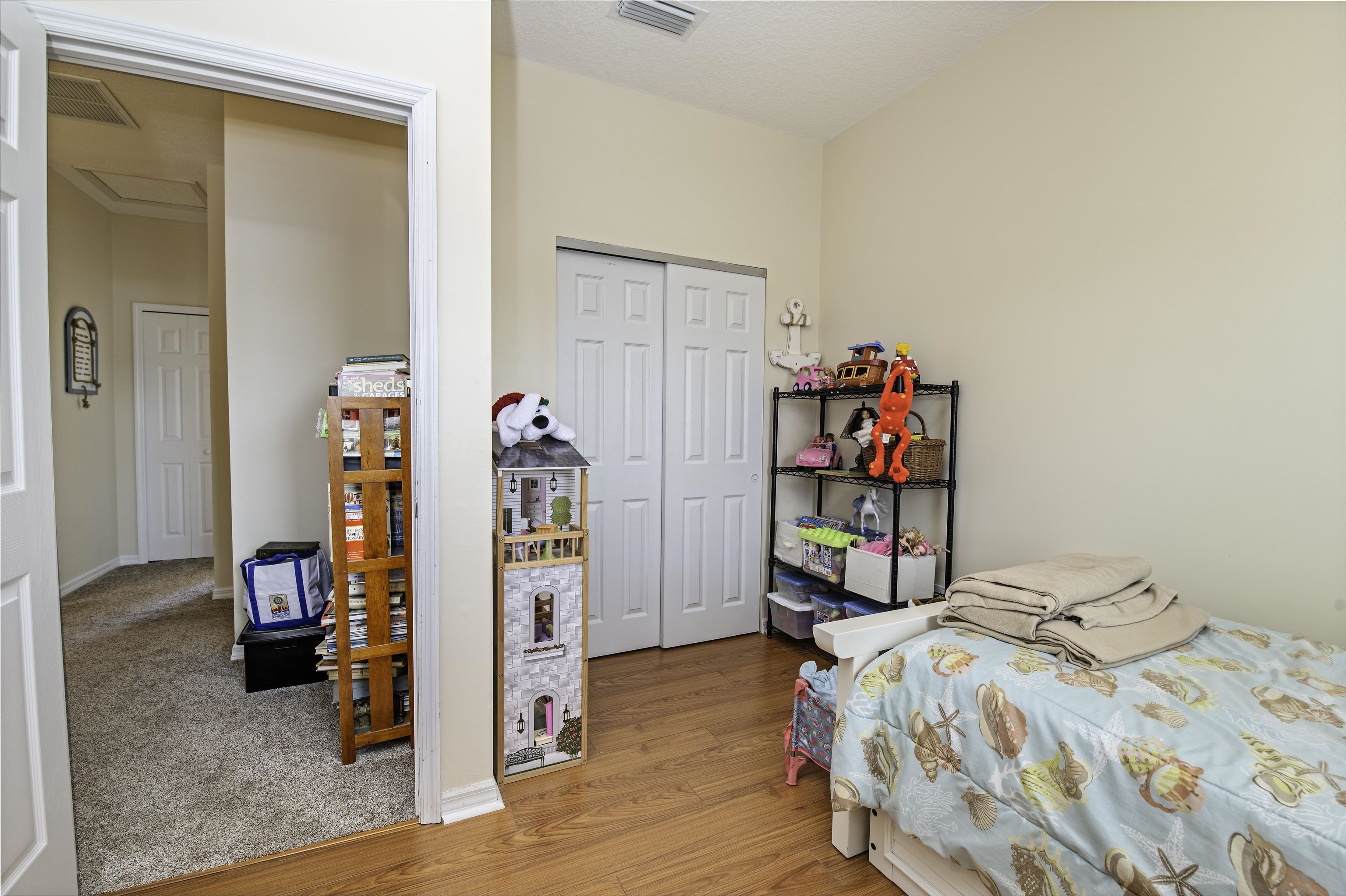 253 Treasure Beach Road St. Augustine, FL 32080 - Photo 32 of 52 a bedroom with a bed and a wooden floor