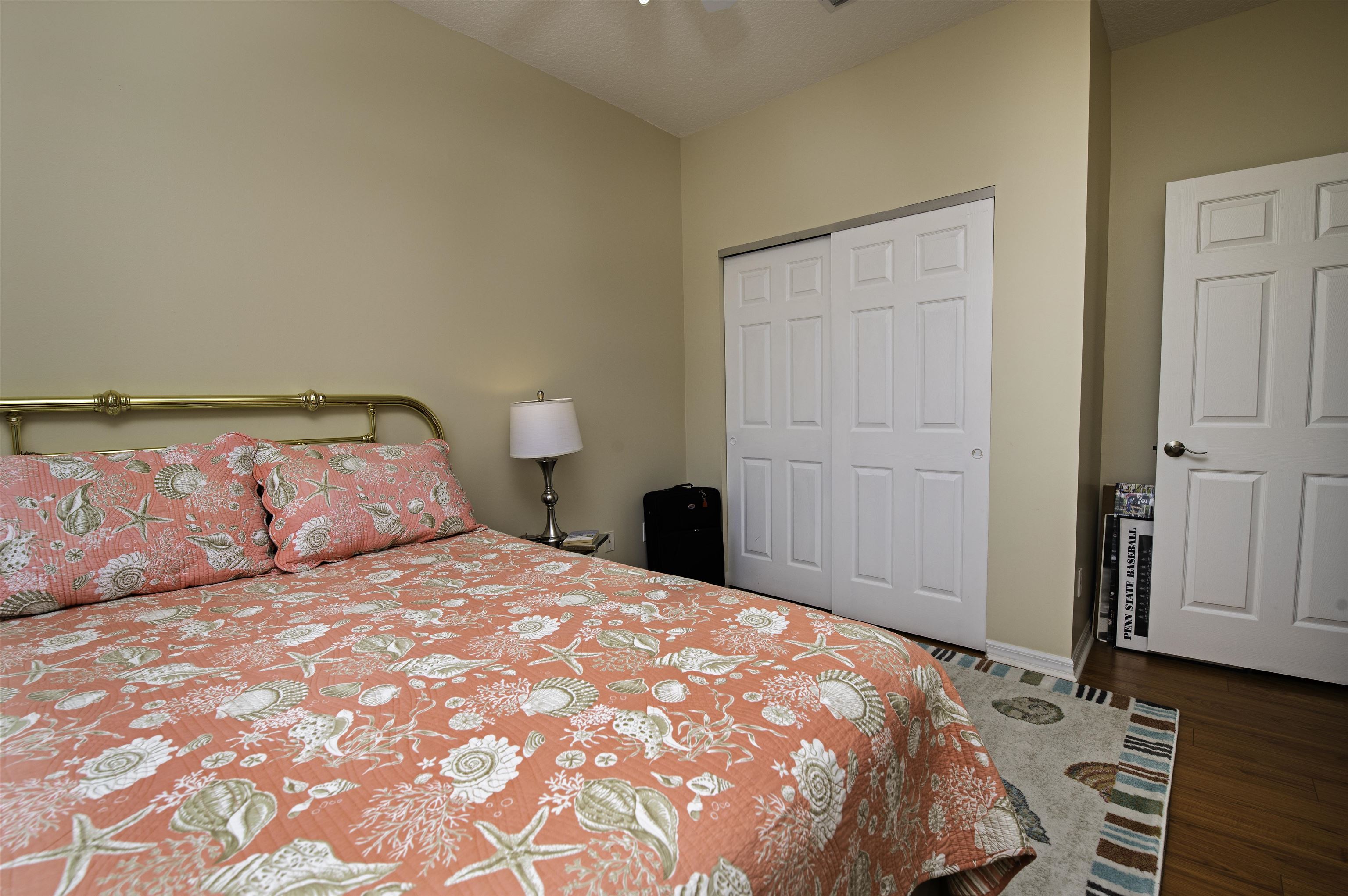 253 Treasure Beach Road St. Augustine, FL 32080 - Photo 36 of 52 a bedroom with a bed and wooden floor