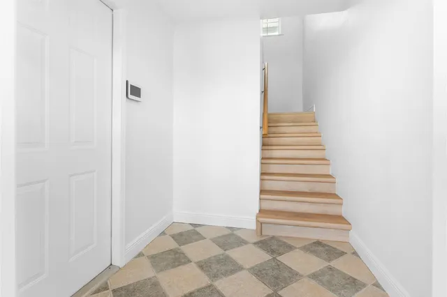 a view of a room with wooden floor and a ceiling fan