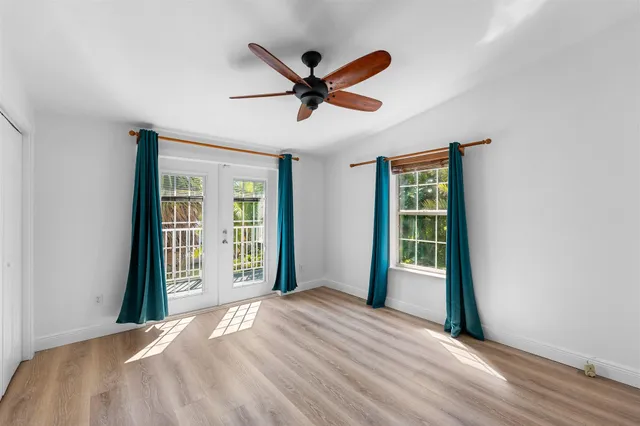an empty room with wooden floor and entryway