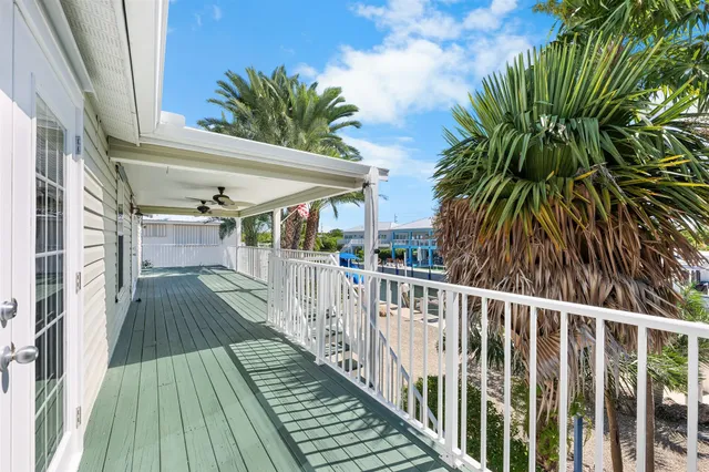 a view of an empty room with window and chandelier fan