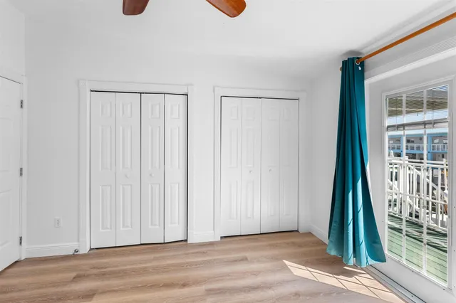 a view of a room with a ceiling fan and window