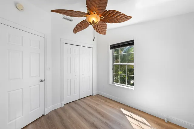 a view of a patio with table and chairs potted plants and large tree