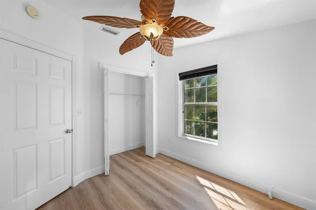 a view of a patio with table and chairs potted plants and large tree