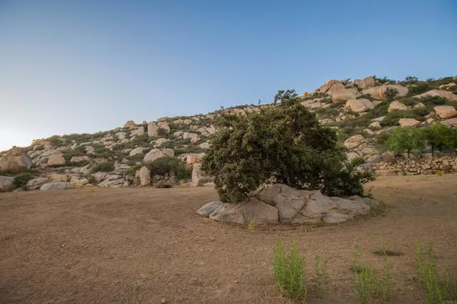 a view of dirt field with mountain in background
