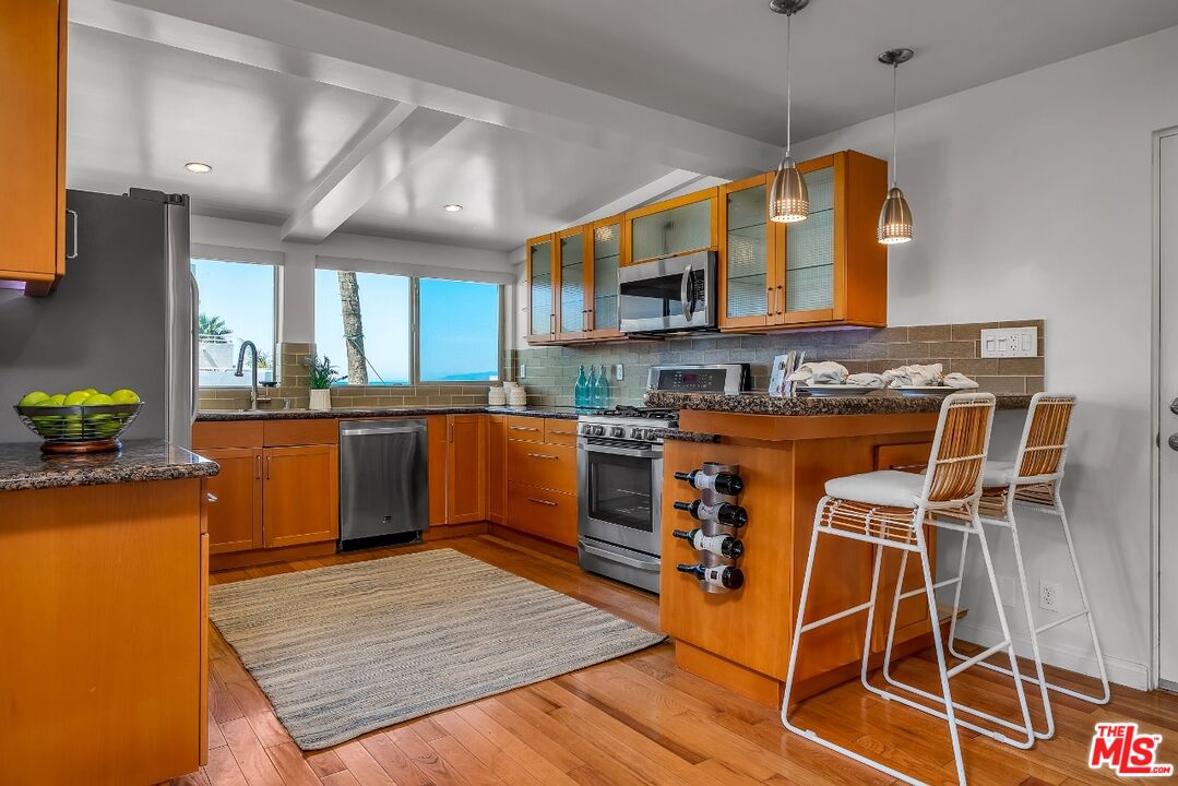 7328 Vista Del Mar Lane Playa del Rey, CA 90293 - Photo 15 of 56 a kitchen with stainless steel appliances granite countertop wooden floors and view of living room
