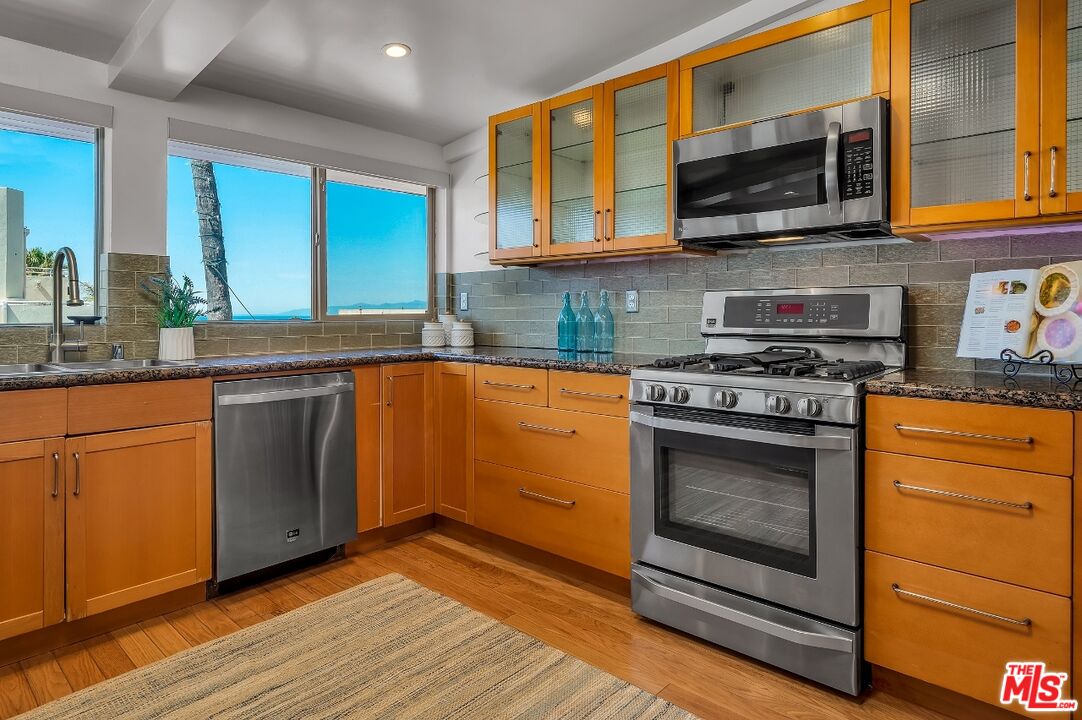 7328 Vista Del Mar Lane Playa del Rey, CA 90293 - Photo 16 of 56 a kitchen with stainless steel appliances granite countertop wooden cabinets granite counter tops and a hard wood floors