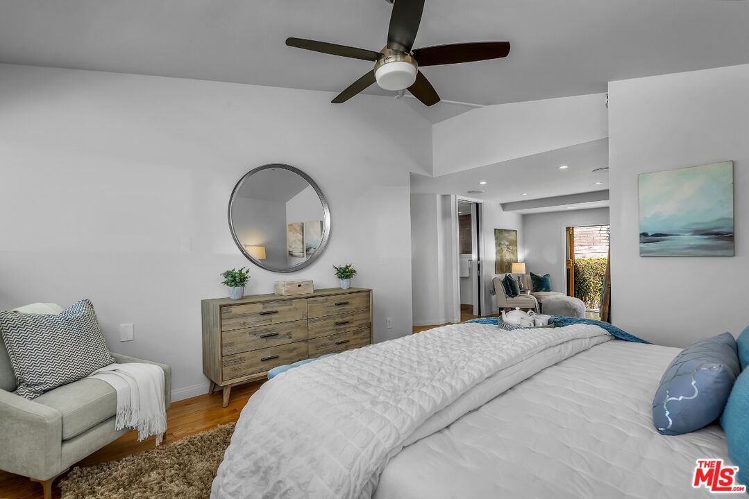 7328 Vista Del Mar Lane Playa del Rey, CA 90293 - Photo 36 of 56 a bedroom with a bed a mirror on the dresser and a chandelier