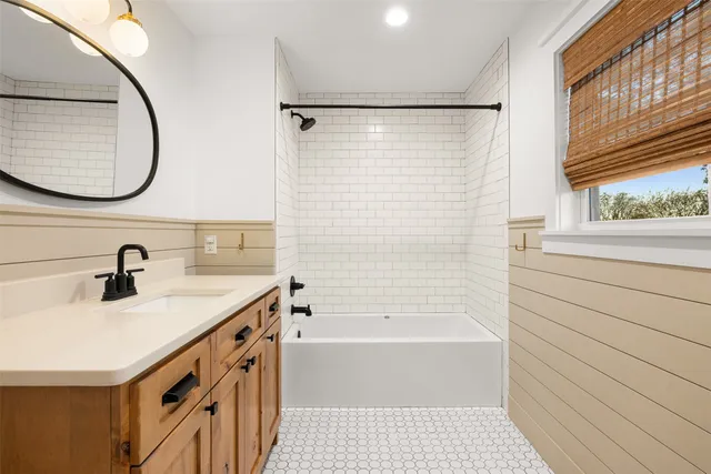 a bathroom with a sink a vanity a mirror and a bathtub