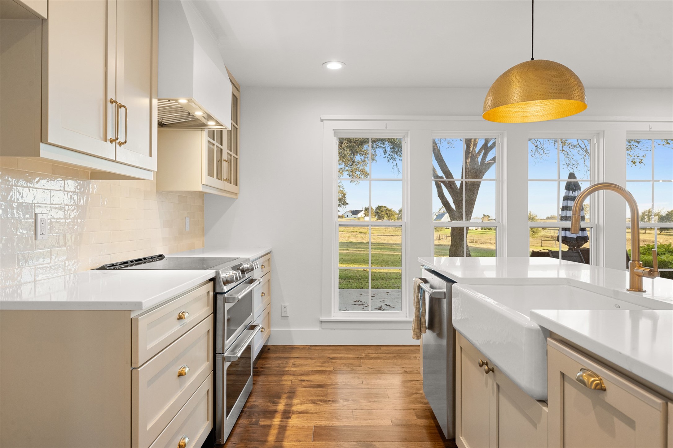 351 Pleasant Hill School Road Brenham, TX 77833 - Photo 25 of 46 a kitchen with stainless steel appliances granite countertop a sink a stove and a wooden floors