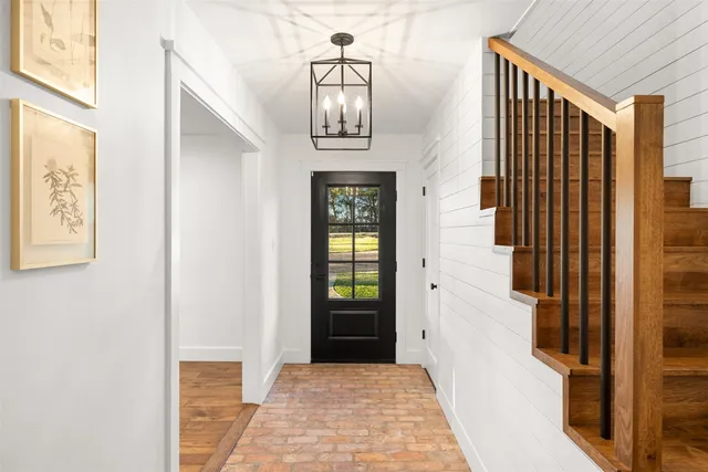 a view of a hallway with wooden floor and staircase