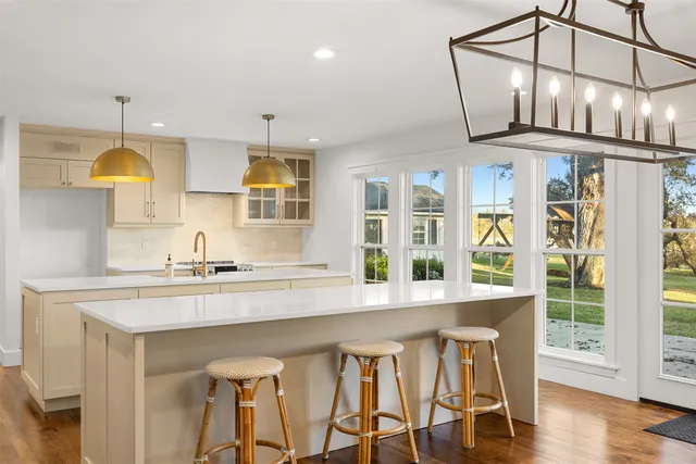 a kitchen with stainless steel appliances granite countertop a stove a sink dishwasher and cabinets with wooden floor