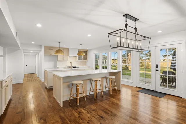 a view of a kitchen with dining space wooden floor electric appliances