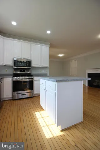 a kitchen with granite countertop a stove a sink and a refrigerator