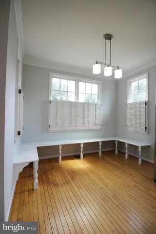 a view of a room with wooden floor and chandelier