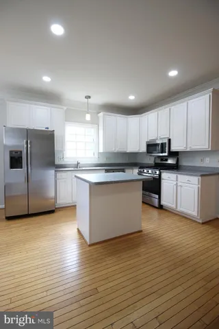 a large kitchen with stainless steel appliances granite countertop a stove a sink and a refrigerator
