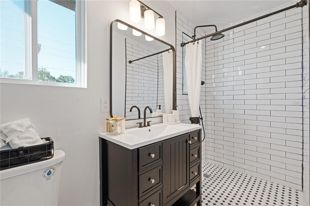 4635 22nd Avenue North St. Petersburg, FL 33713 - Photo 9 of 20 a bathroom with a sink a toilet and a mirror