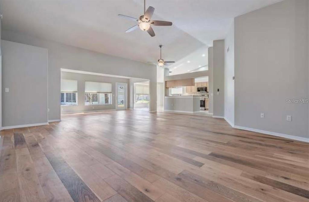 1520 Canberley Court Trinity, FL 34655 - Photo 7 of 35 a view of an empty room with wooden floor and a ceiling fan